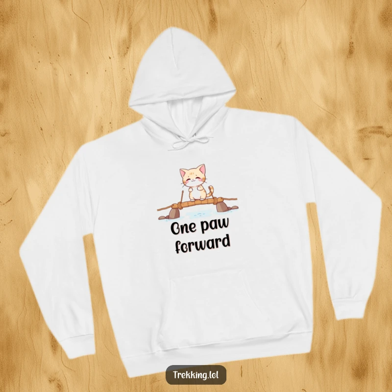 Funny hoodie featuring a giggling cat character fearlessly crossing a precarious rope bridge, conveying a sense of daring fun.