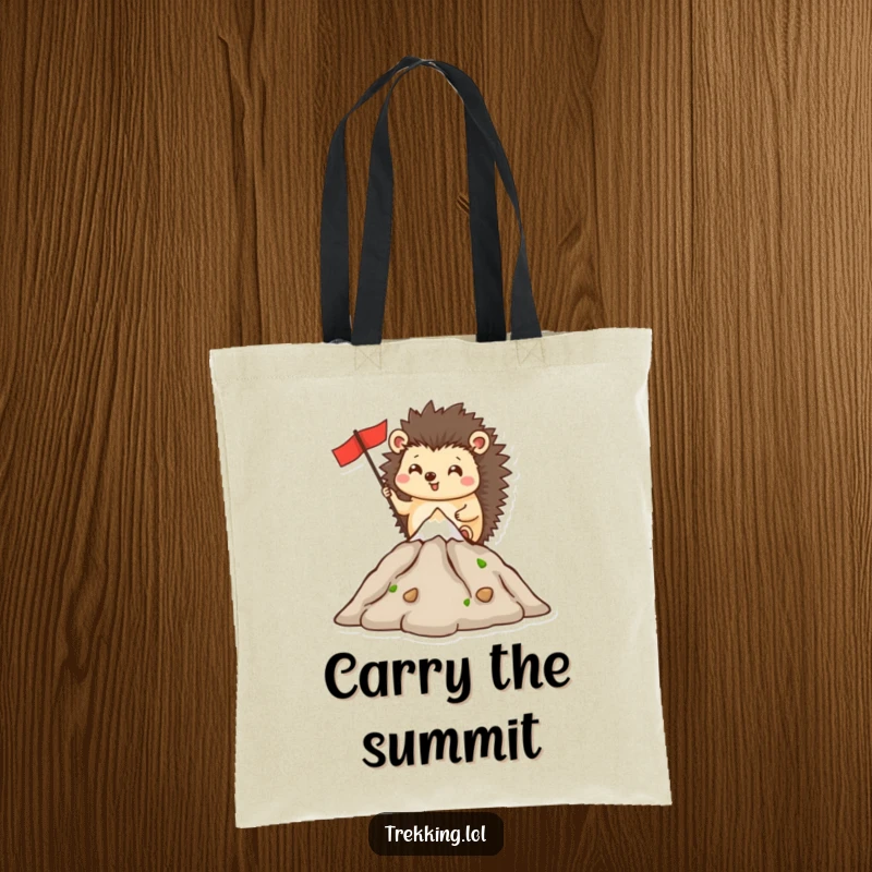 Funny tote bag depicting a happy hedgehog planting a flag on a small mountain summit, celebrating determination.