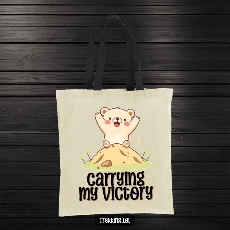 Funny tote bag showcasing a happy bear cheering at the peak of a small hill, ideal for carrying essentials with a humorous touch.