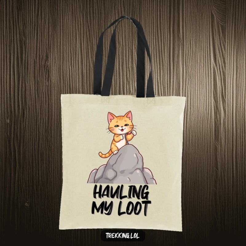 Funny tote bag depicting a determined cat using a small grappling hook to climb a rock, great for daily use.